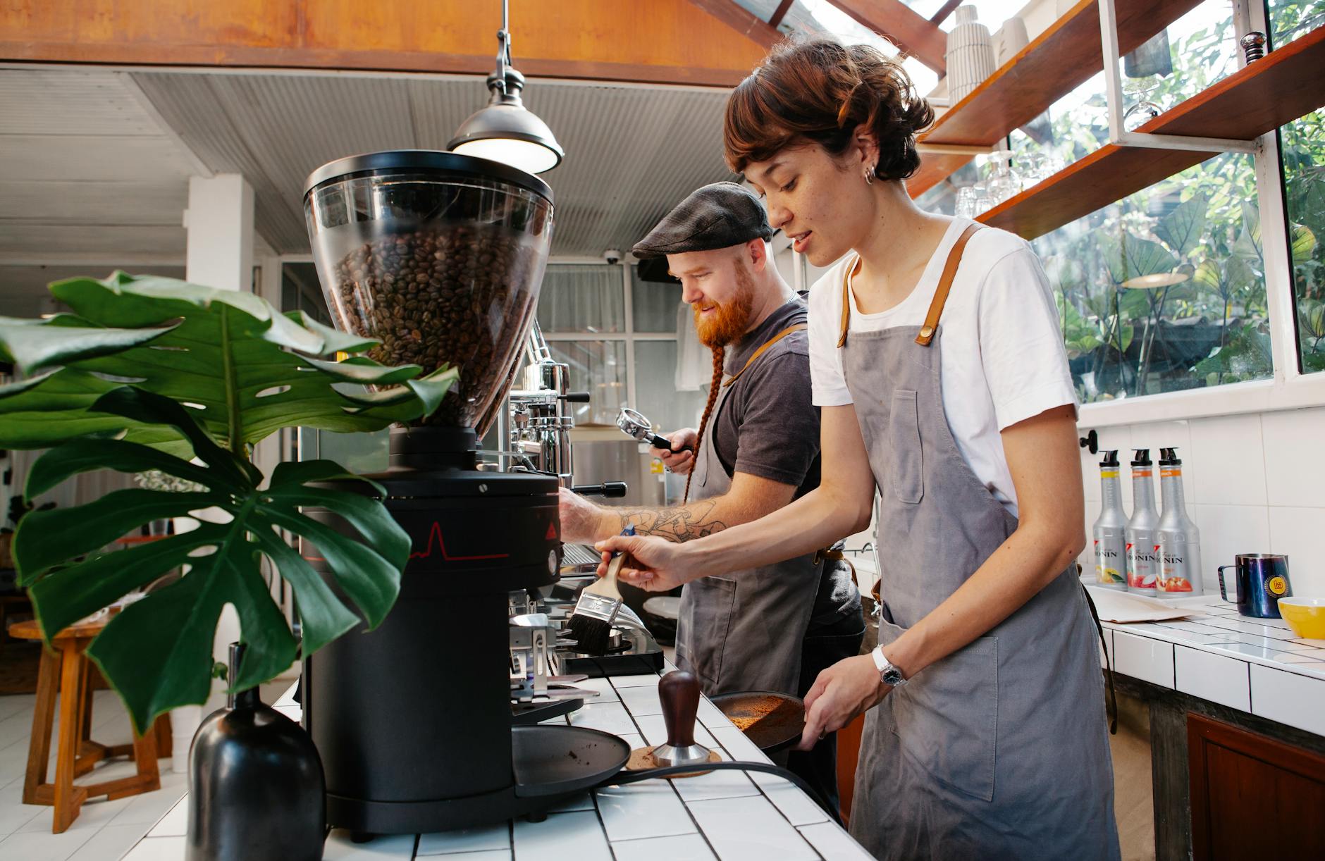 baristas preparing coffee in machines in cafe kitchen